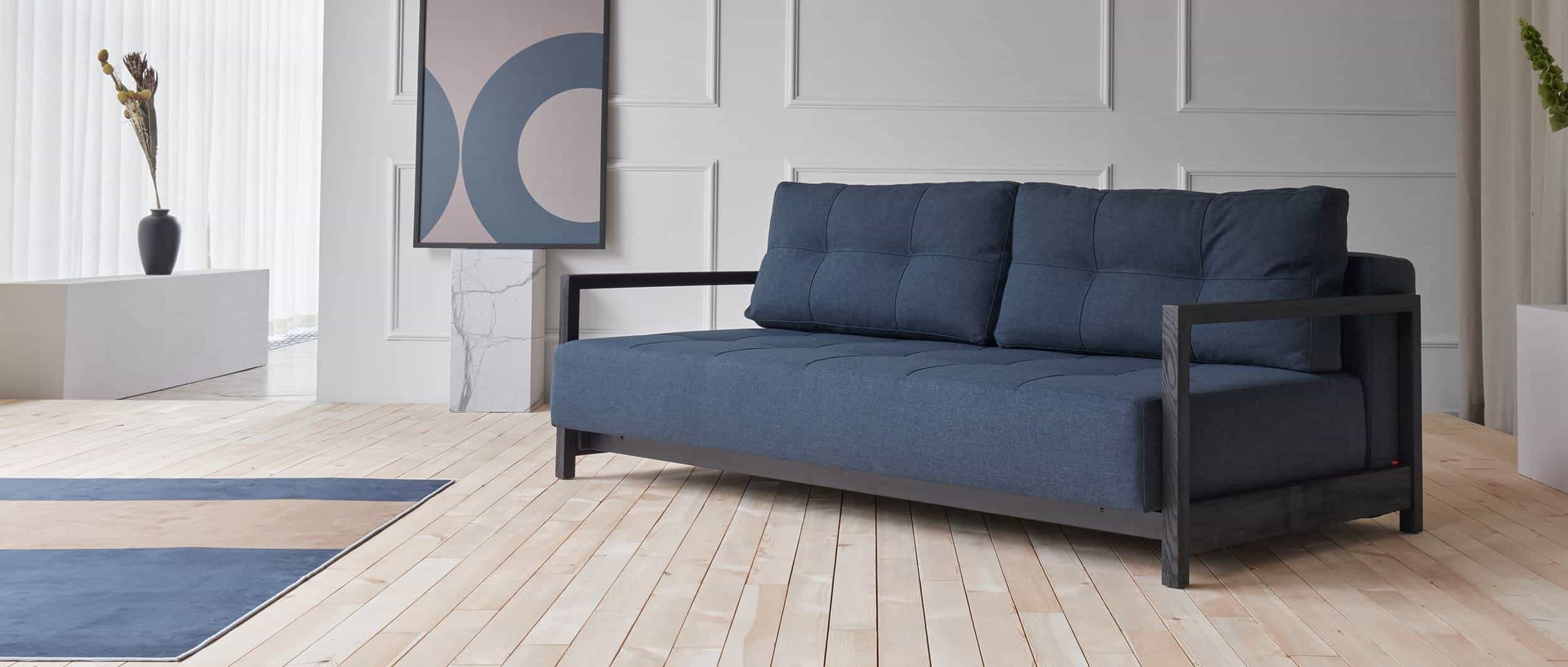 blaues Lounge Sofa mit schwarzen Holzarmlehnen, Gästebett für 2 Personen - 155x200cm